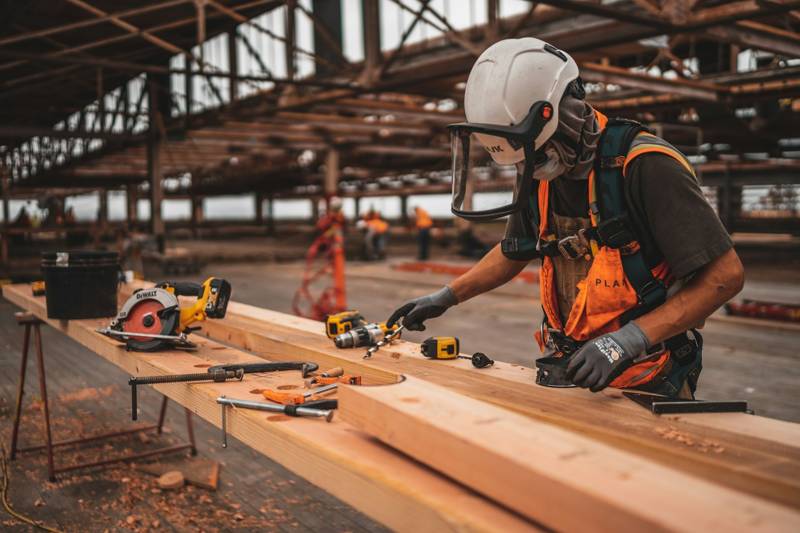 Carpenter measuring and cutting trim on a job site